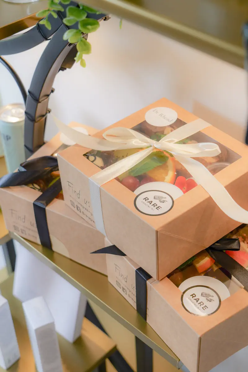 Ribbon-tied grazing boxes of fresh fruit and treats stacked for guests at The Signature Event.
