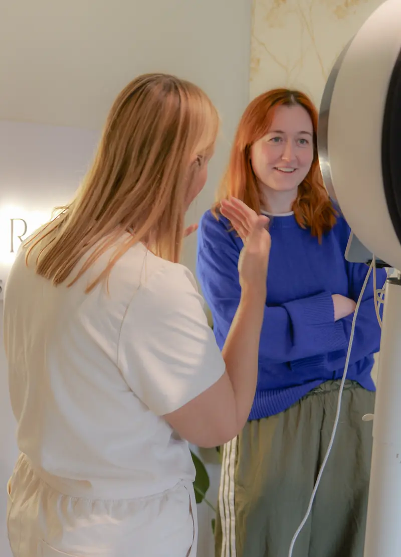 A guest listening as a Dr Rhead Aesthetics team member talks through the Observ skin scan.